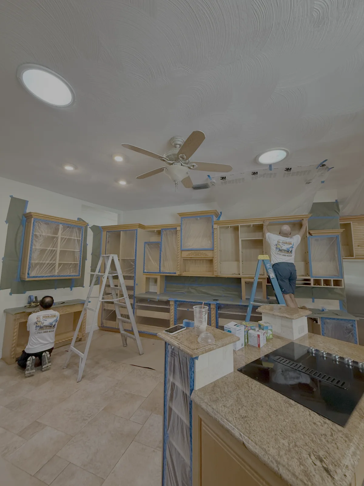 Cabinet refinishing prep with careful surface masking on a Tampa kitchen - Premier Contractors FL